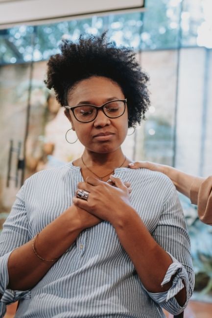 woman eyes closed holding hands to chest