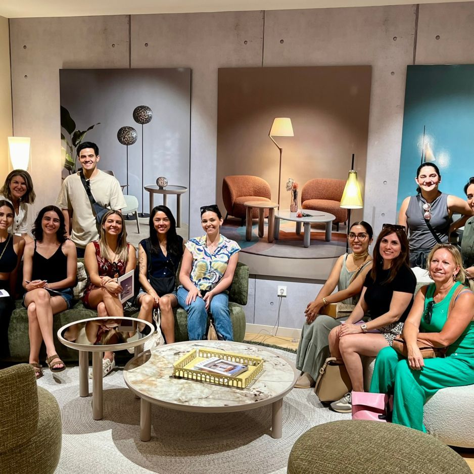 Alumnos de diseño de interiores en un showroom de Madrid con butacas, lámparas y mesas.