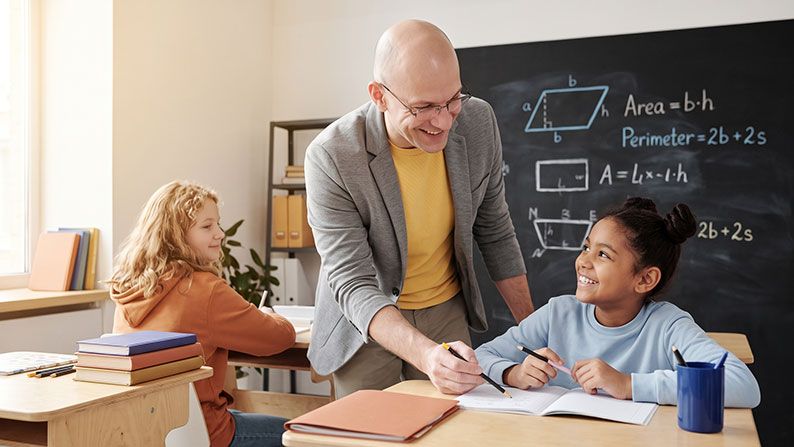 Ein Schulbegleiter im Klassenzimmer hilft einer Schülerin