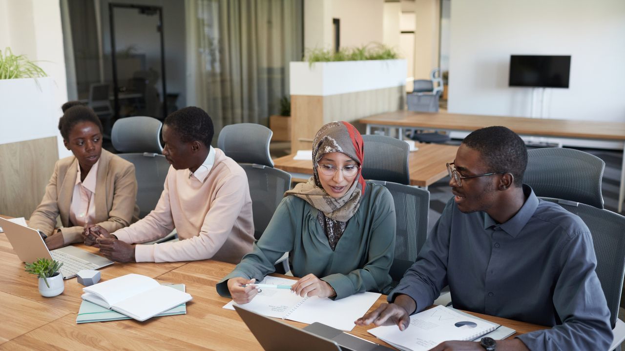 A team discussing a workplace policy around a meeting table