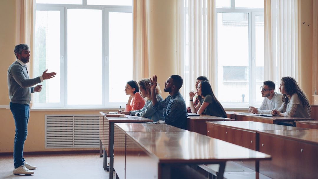 A lecturer standing in front of students sat at tables