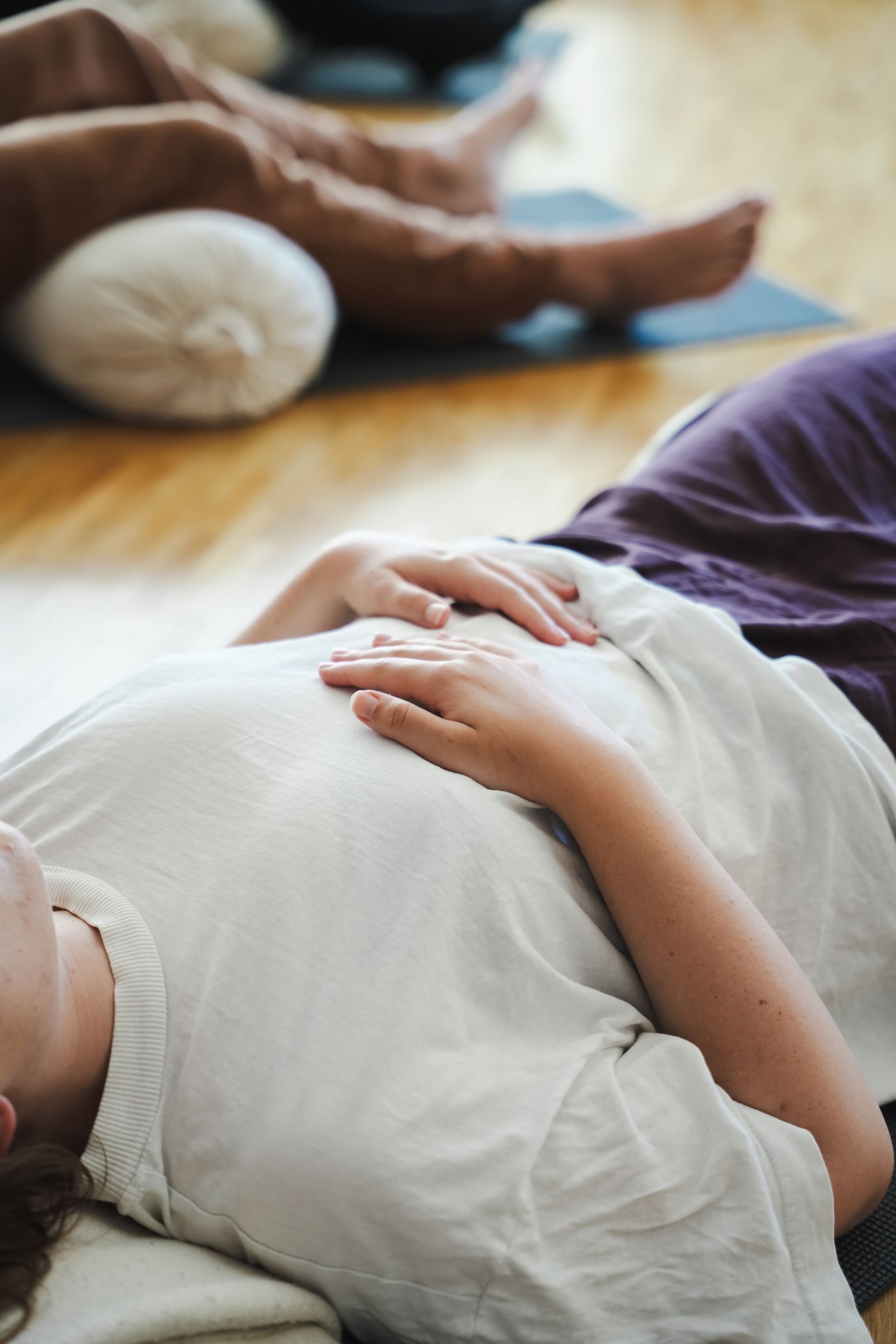 Close detail of hands resting on the chest during a breathwork session
