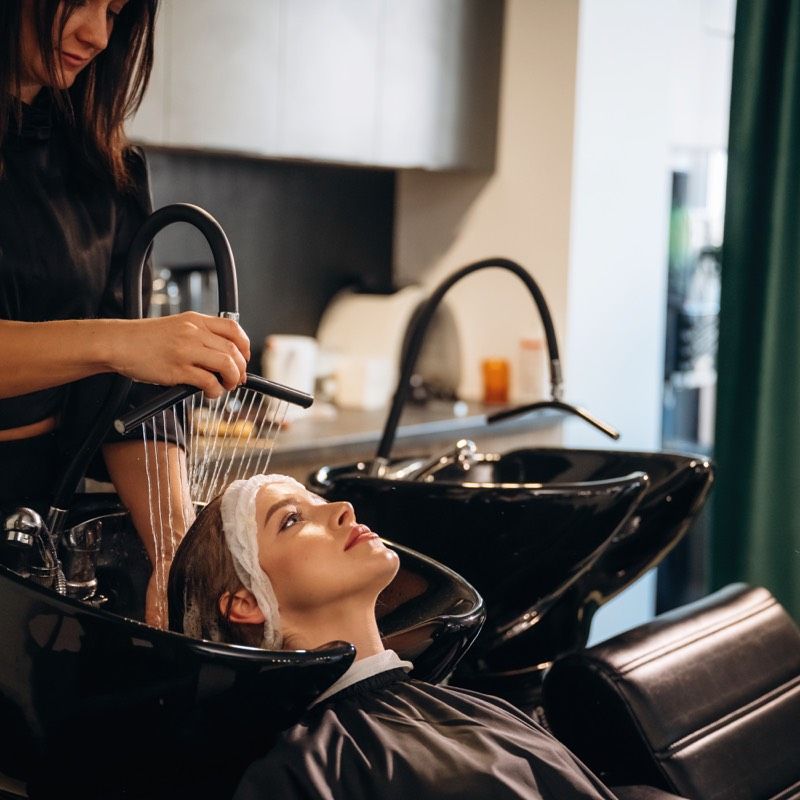 Stylist washing a client's hair