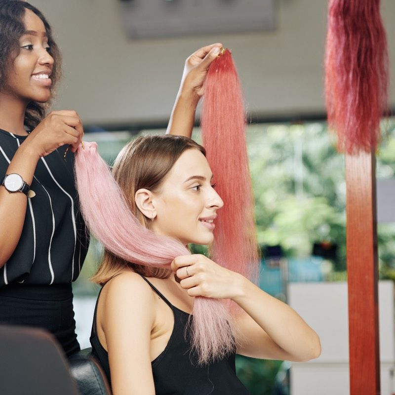 Stylist attaching pink hair extensions