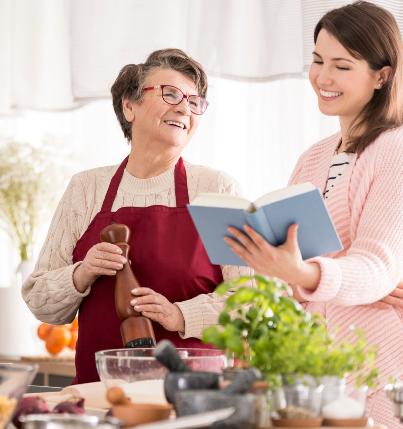 Older woman holding pen, middle aged woman assisting her at table