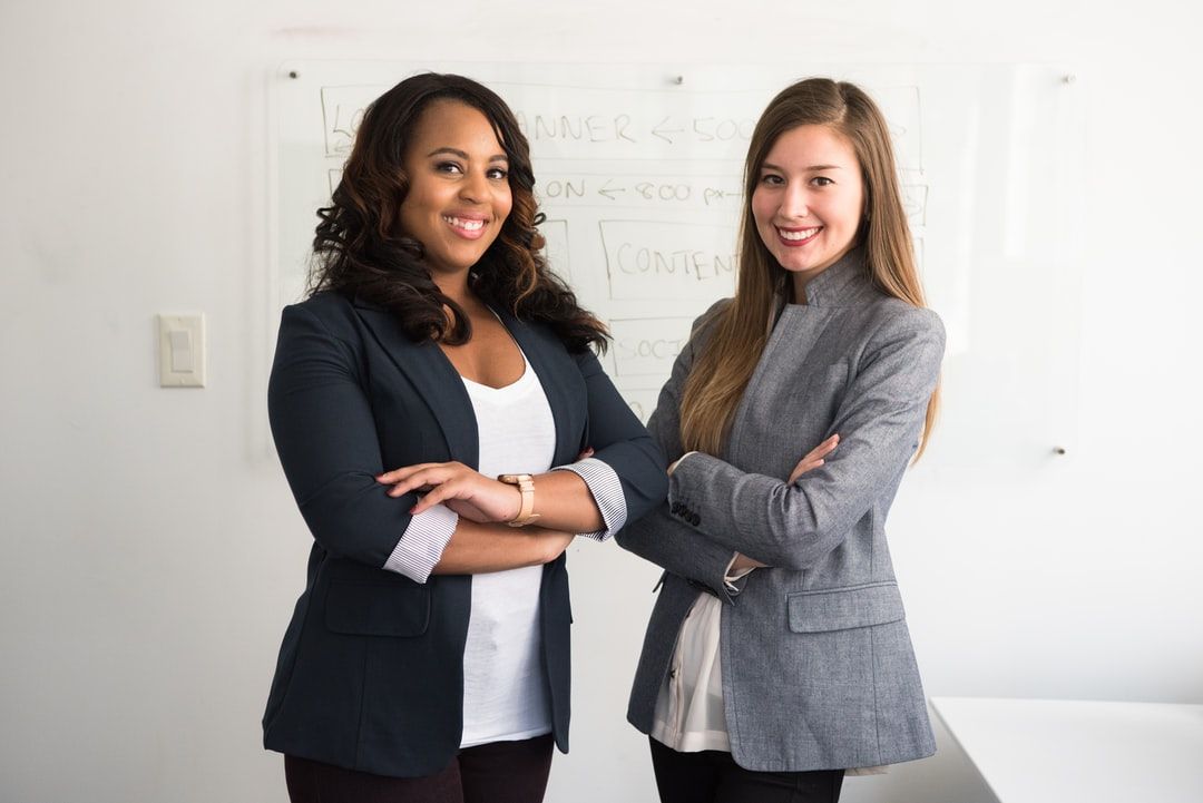 photo of two women in business suites with arms crossed