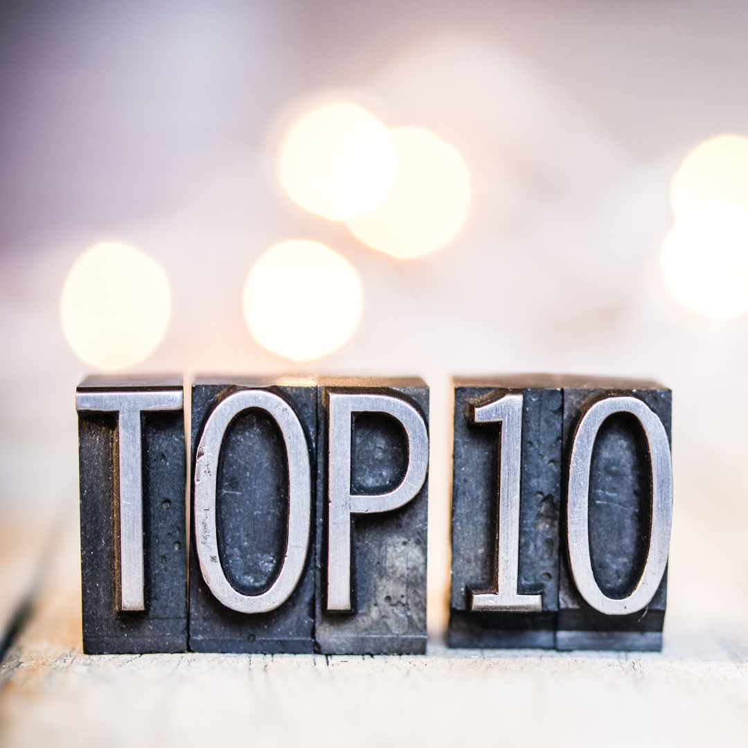 image with blurry lights and light background with metal tiles that have letters on them that spell "TOP 10"