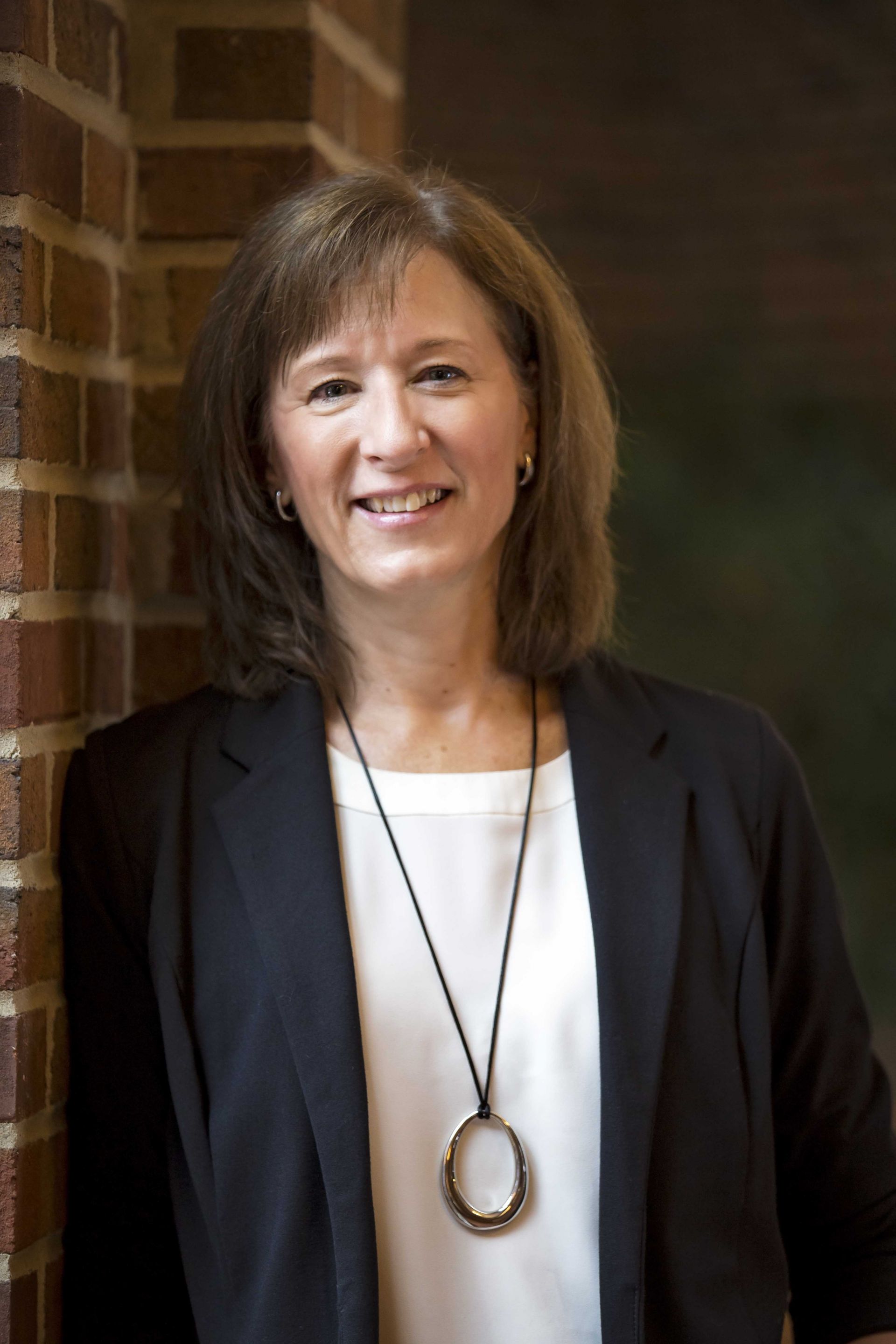 Photo of Martha Theisen leaning against a brick wall