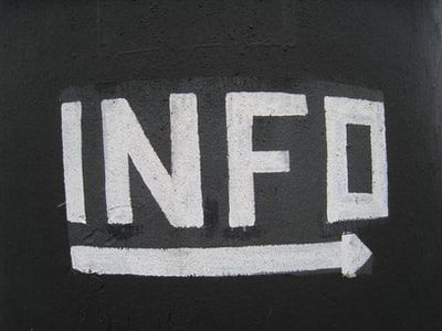 black square with white chalk writing in capital letters reading "INFO" with a arrow pointing to the right