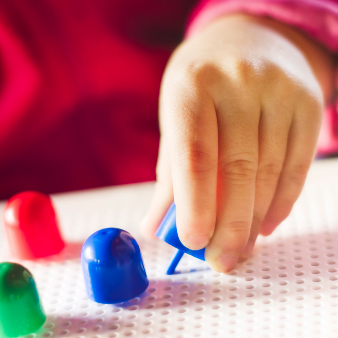 photo of hand placing peg in pegboard