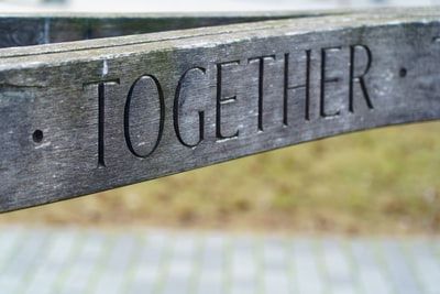 Wooden fence rail with word "Together" carved on it