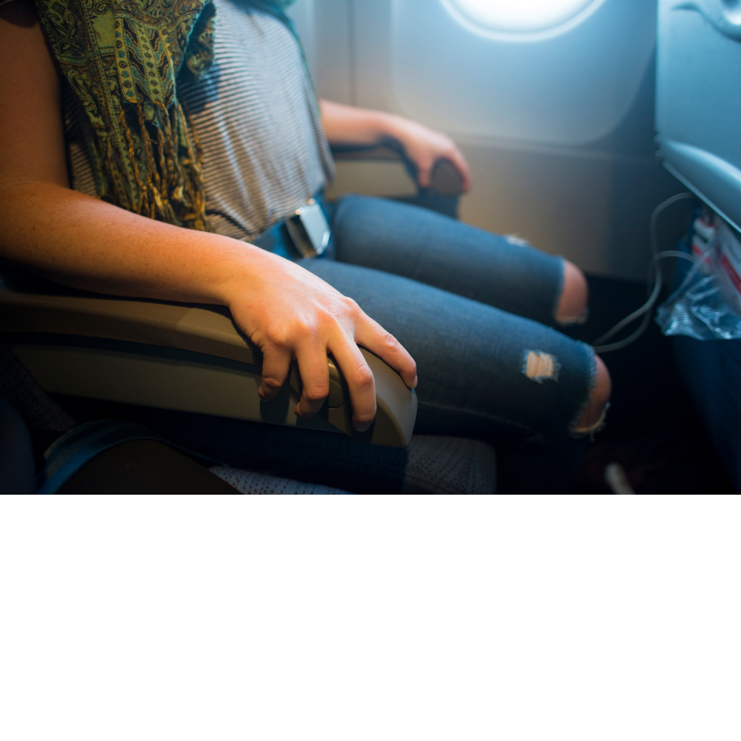 Photo of a woman seated in a plane seat gr