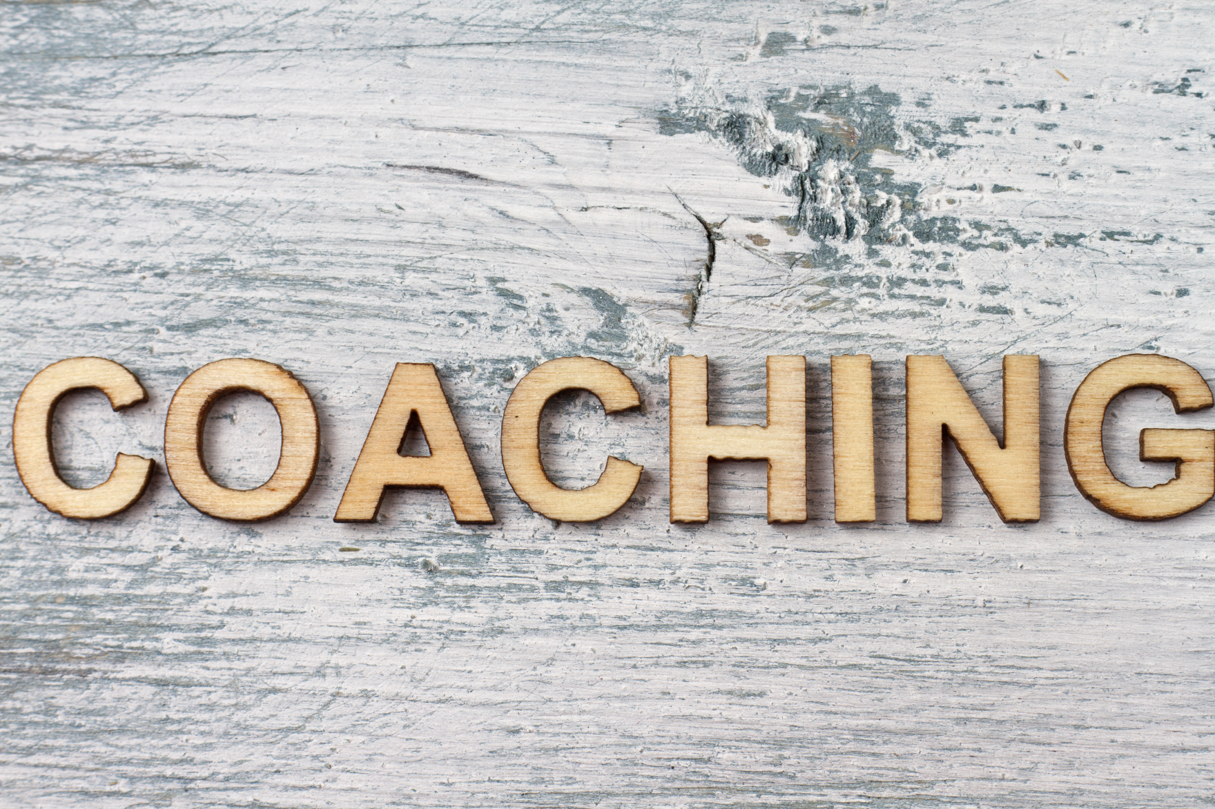 image of wood with gold letters spelling "Coaching"