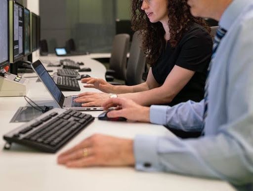 A woman and a man using computers