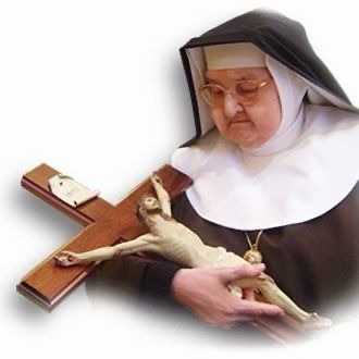 Mother Angelica holding a crucifix in her arms