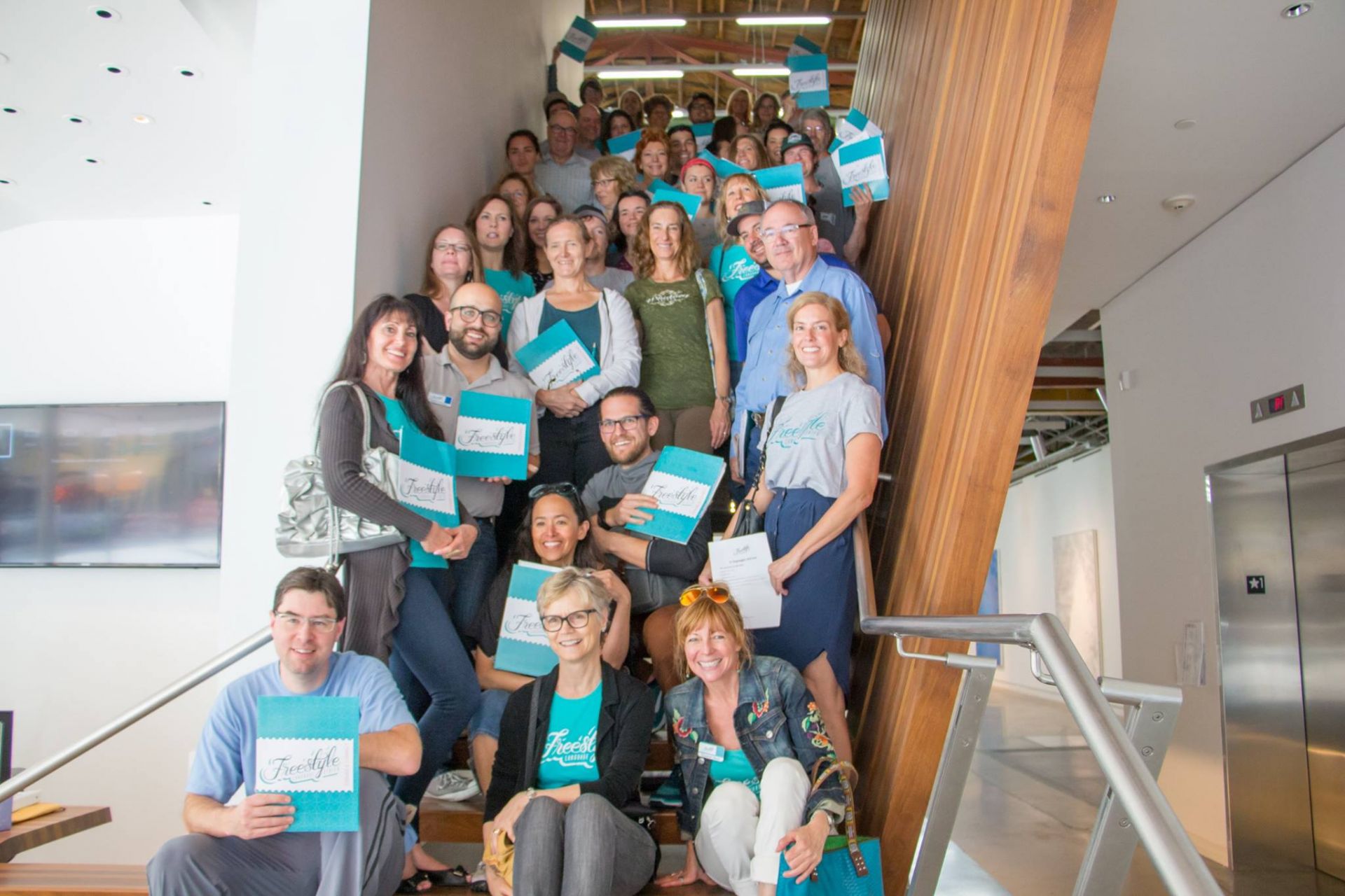 Freestyle learners and instructors smiling with their Freestyle themed folders