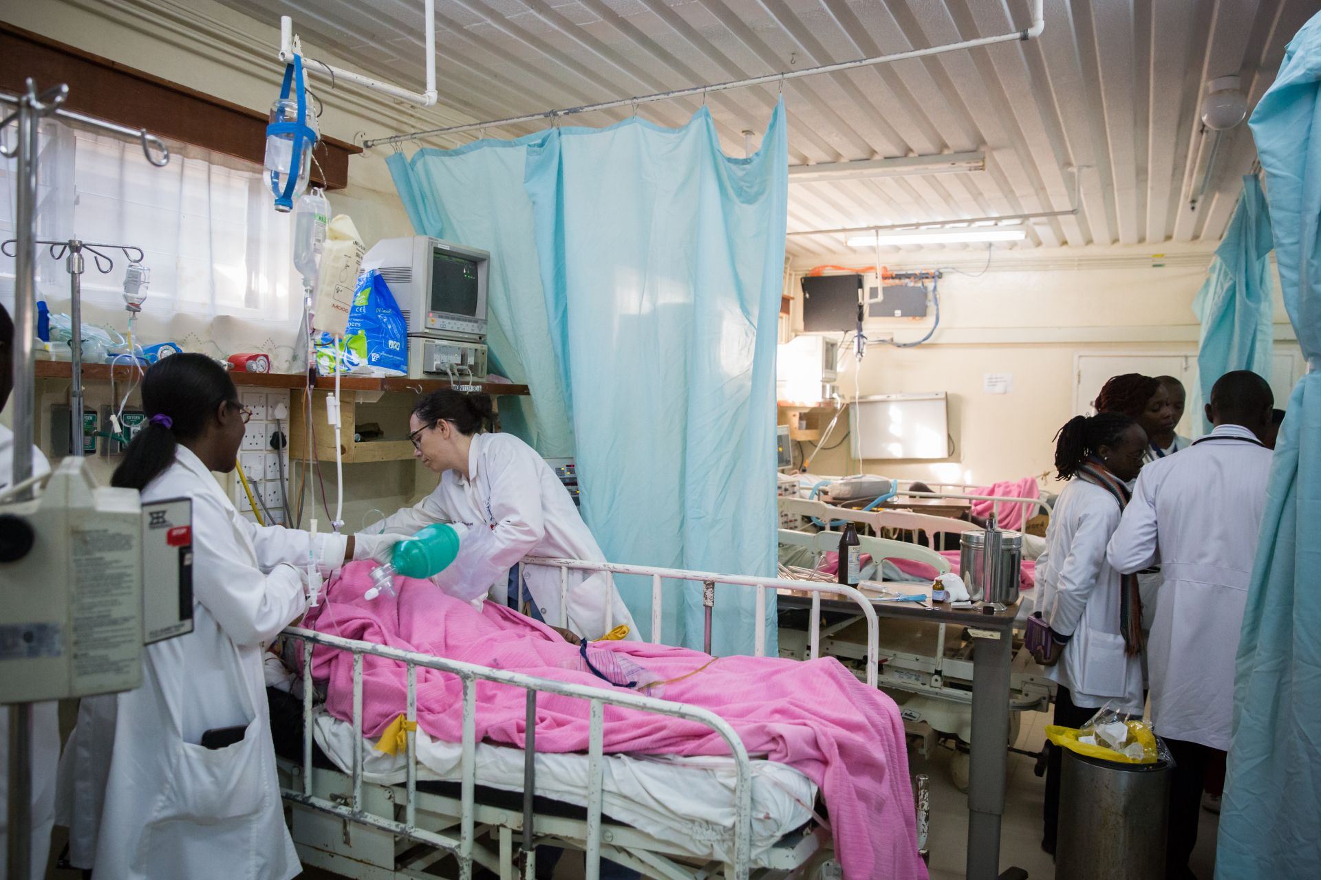 Dr. Andrea Parker at a patient’s bedside in the intensive care unit at AGC Tenwek Hospital, with colleagues