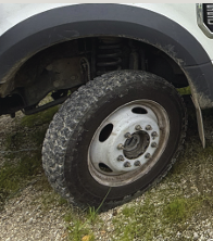 Truck tire with soil and vegetation showing how invasive species can spread between ROW sites if equipment isn’t cleaned.