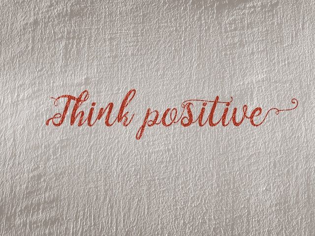 mots think positive peints sur un mur blanc
