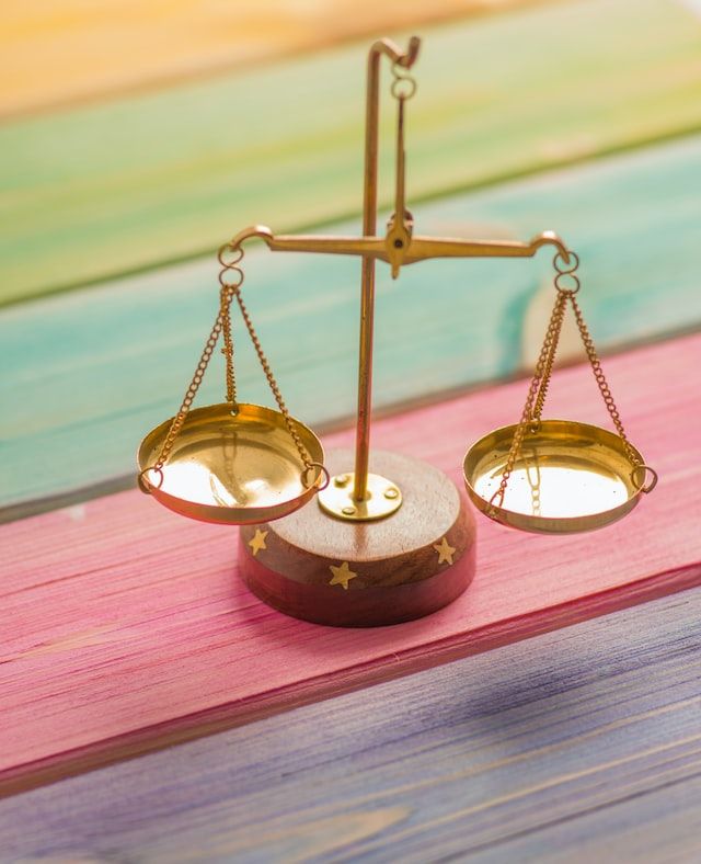 balance à poids posée sur une table en bois colorée