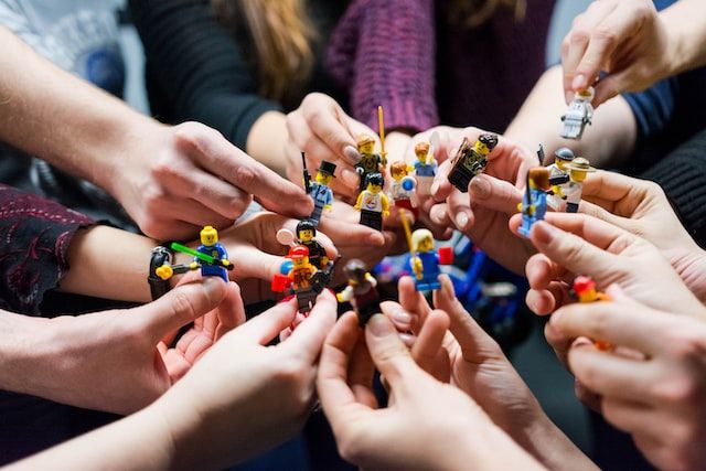 figurines de Lego tenues par plusieurs personnes