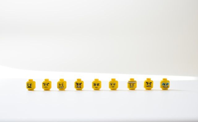 têtes de figurines Lego alignées sur un support