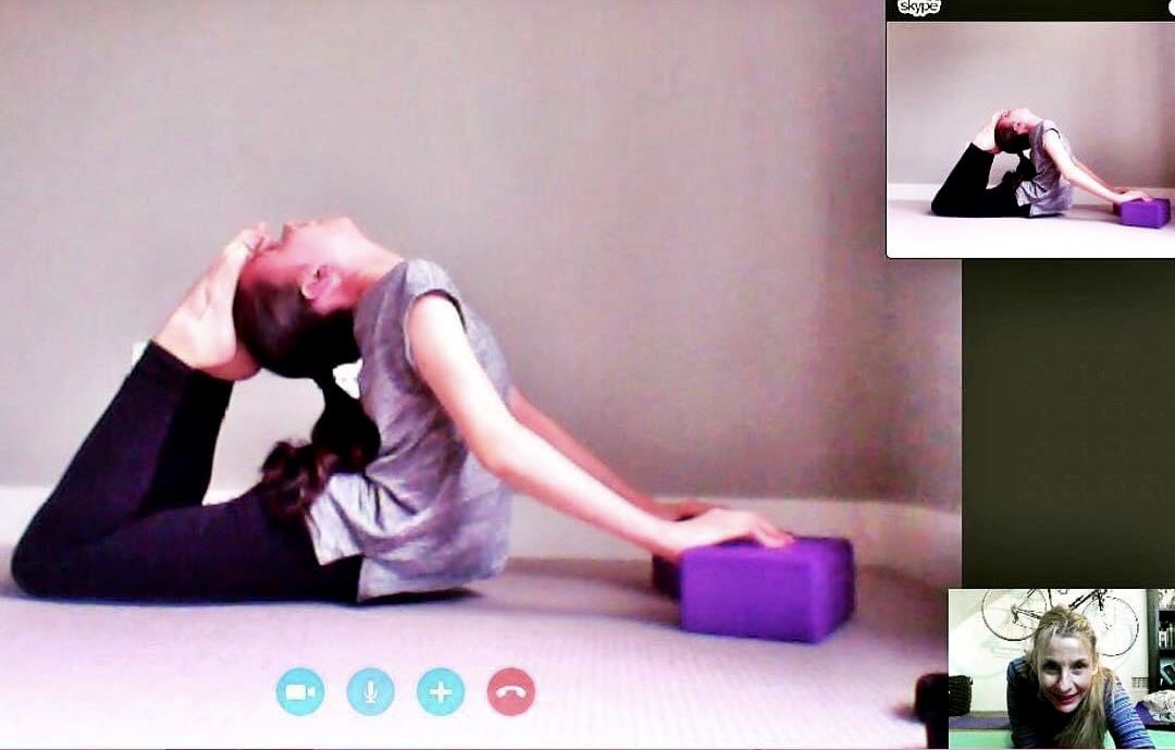 girl on stomach arching back pushing on 2 yoga blocks in King Cobra Pose