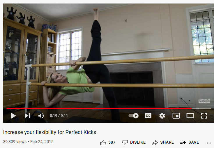 Stacey demonstrating how to improve side kick drill holding a bar
