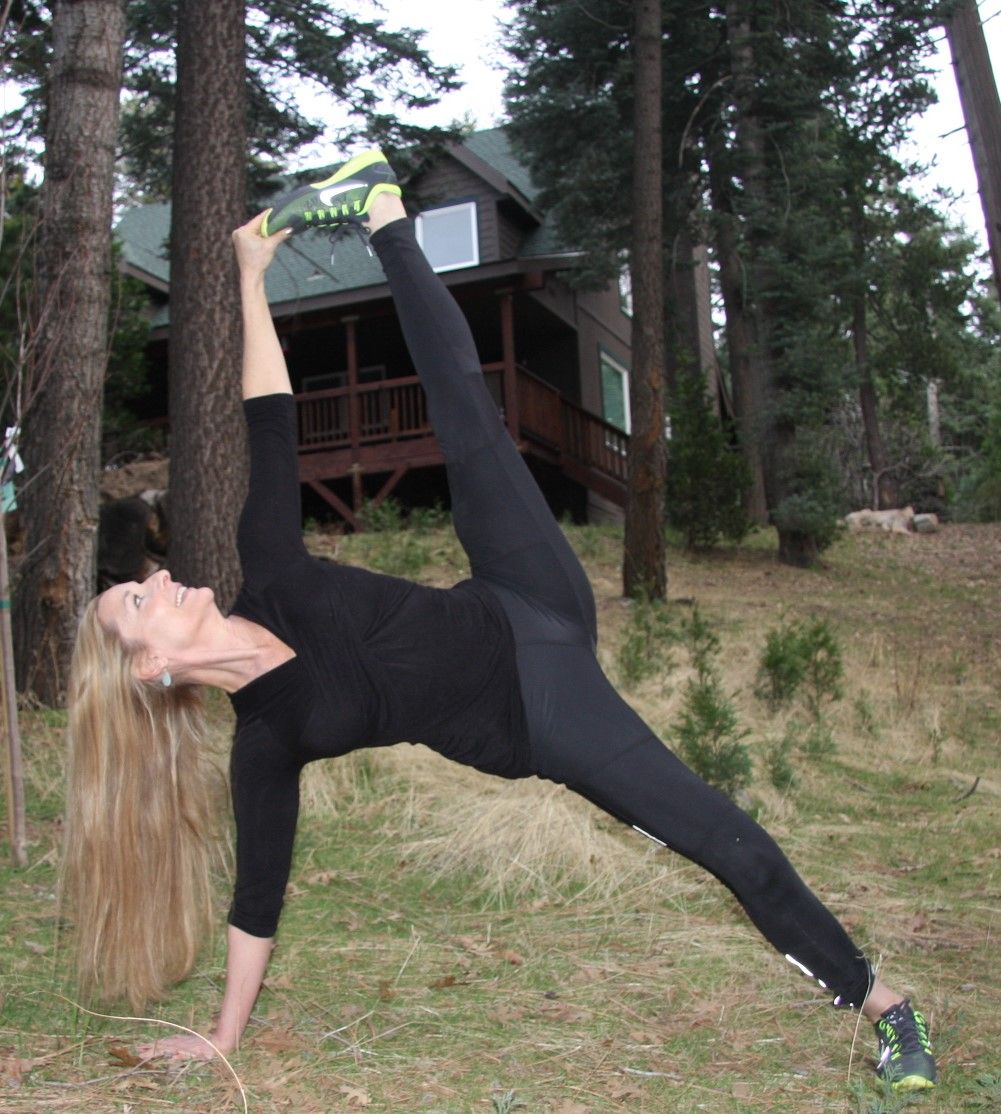 Stacey half moon pose sideways balancing on 1 hand while holding foot with other hand
