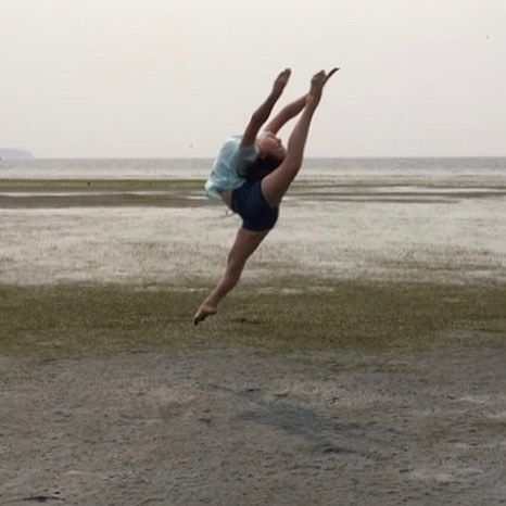 Dancer in firebird leap at beach