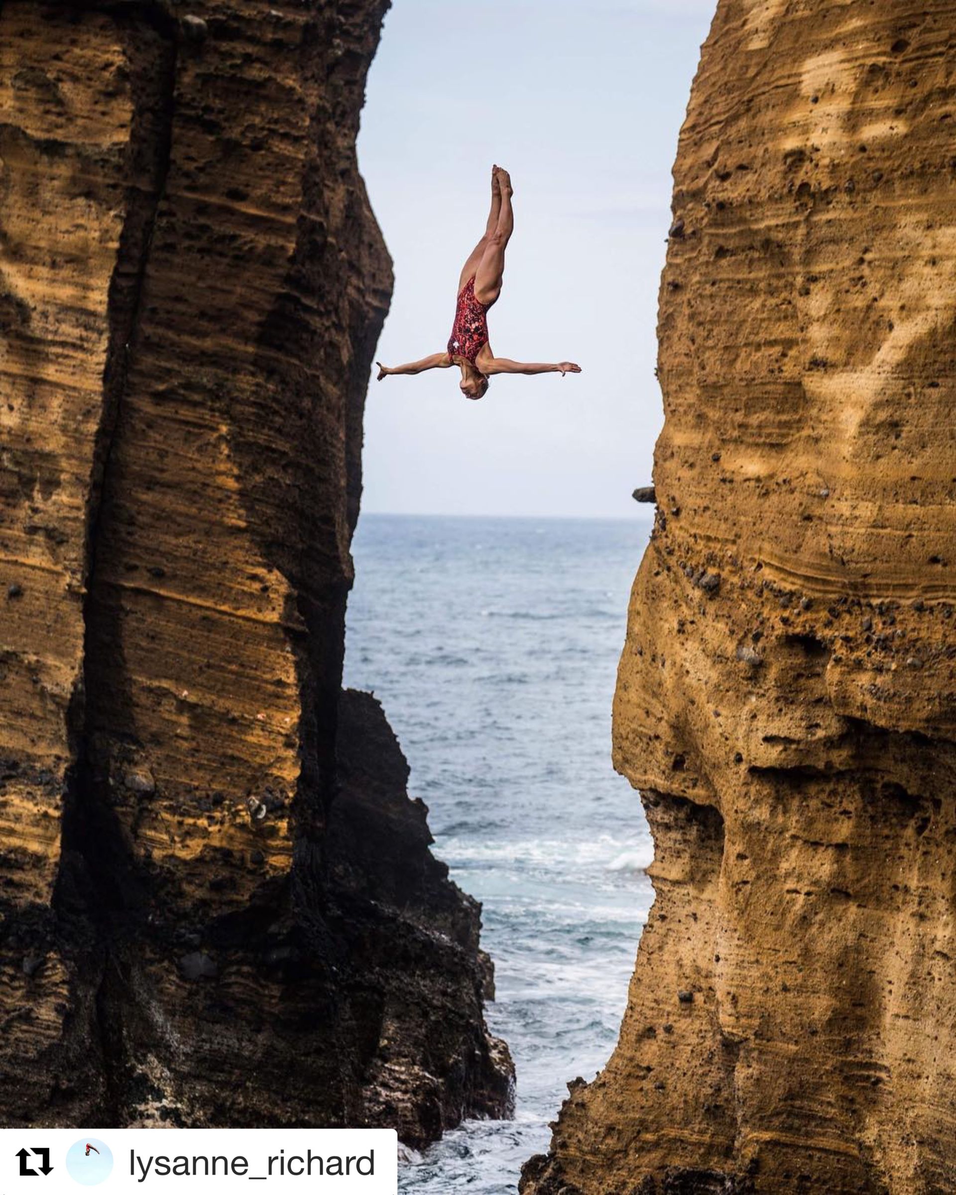 Female red bull high dive champion high diving off a cliff 