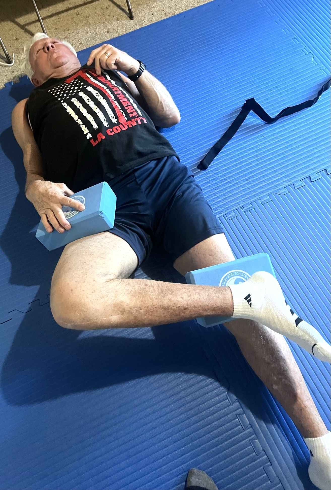 Man lying  on matt performing a hip stretch
