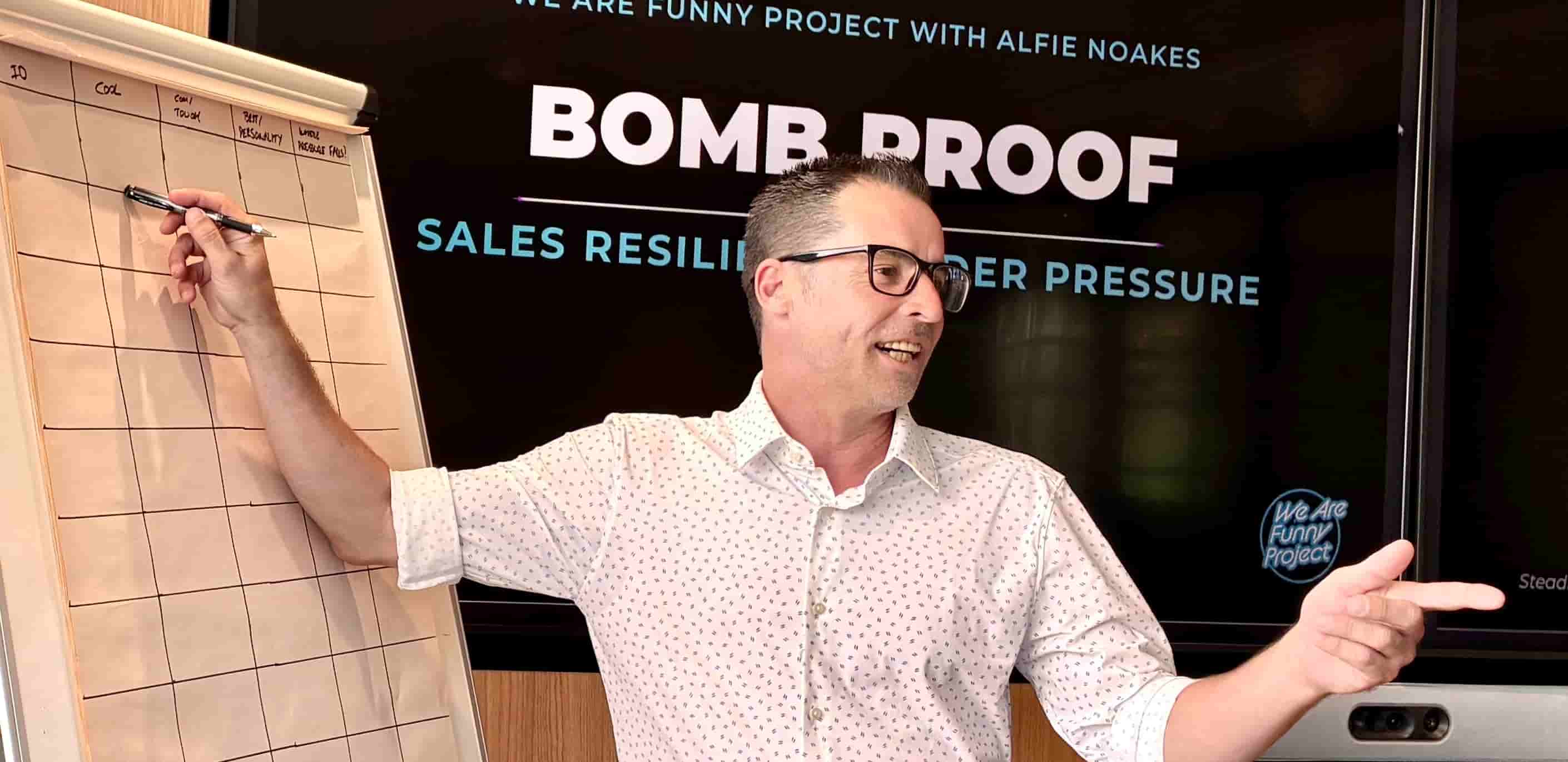 Alfie Noakes smiling at the camera at FIS event with we are funny project logo in the background