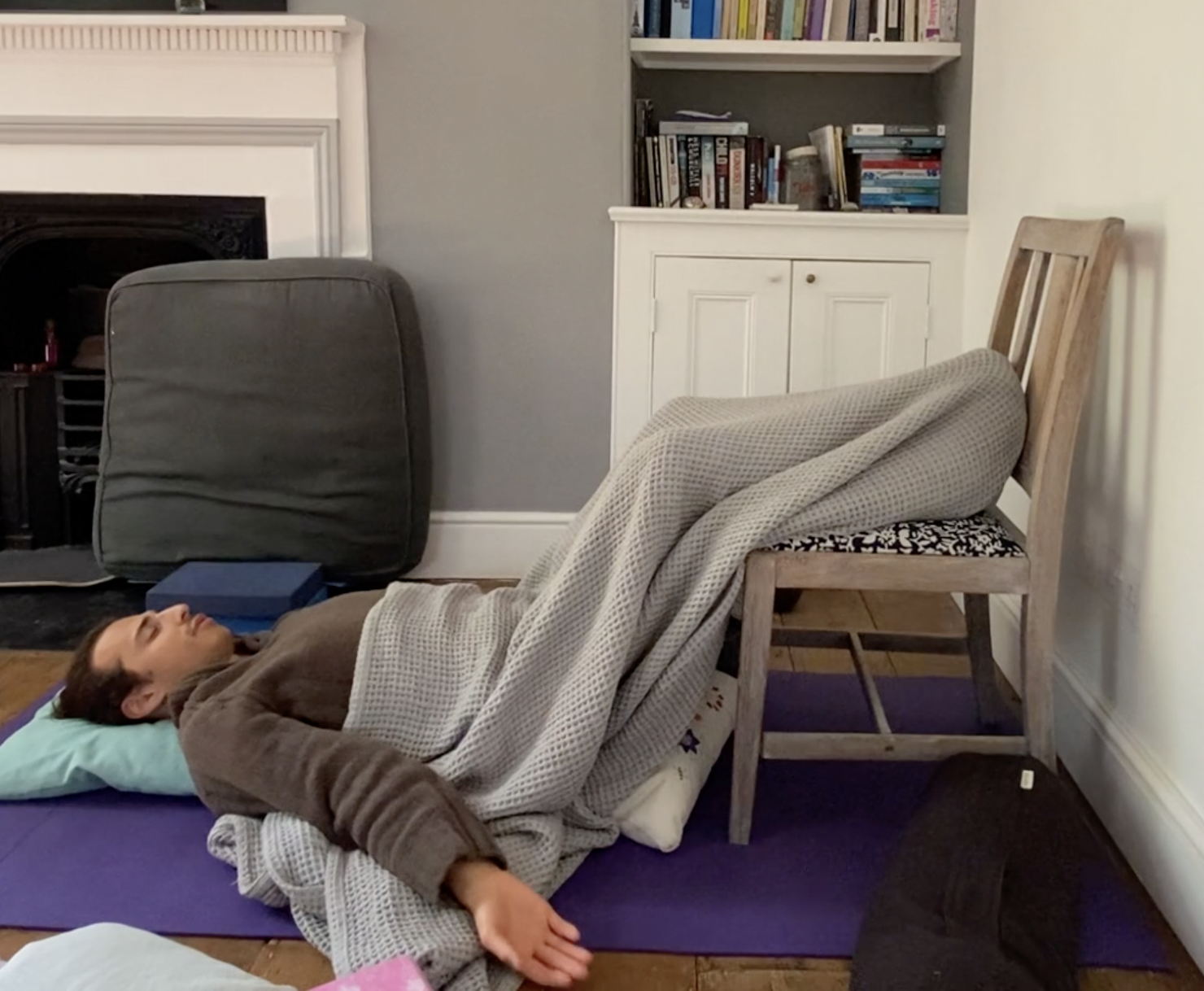 Man lying on the floor at home practicing NSDR for fatigue.