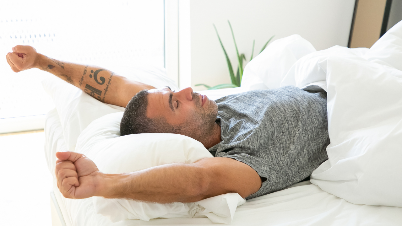 stock image of man stretching in bed