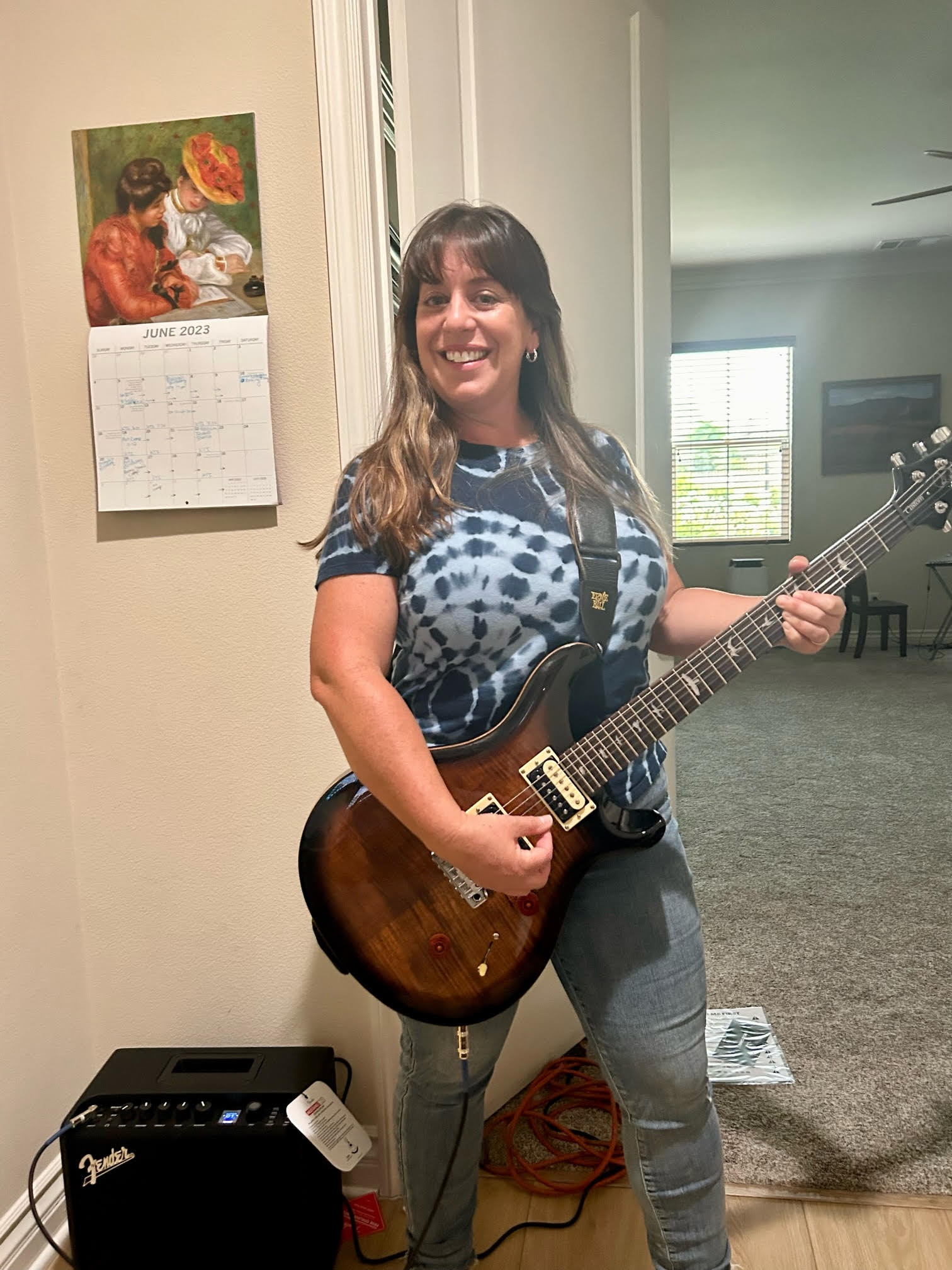 Women smiling, holding guitar