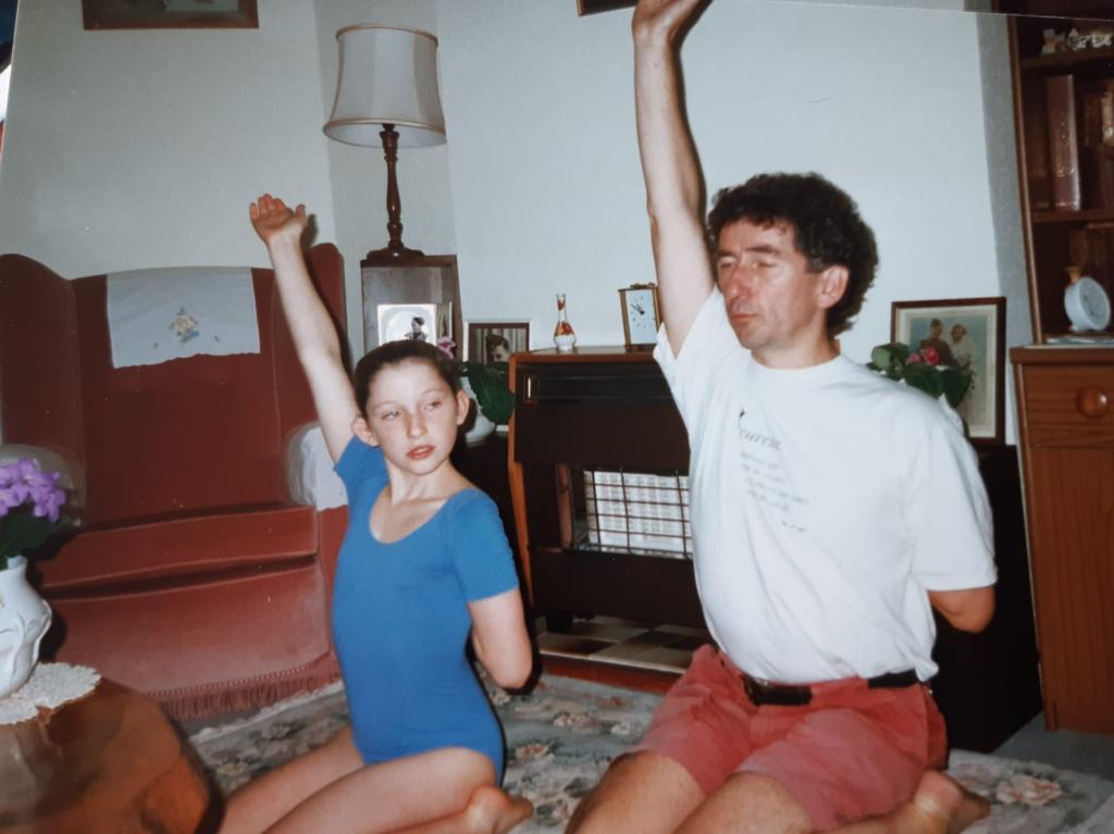 Father and daughter practicing yoga together