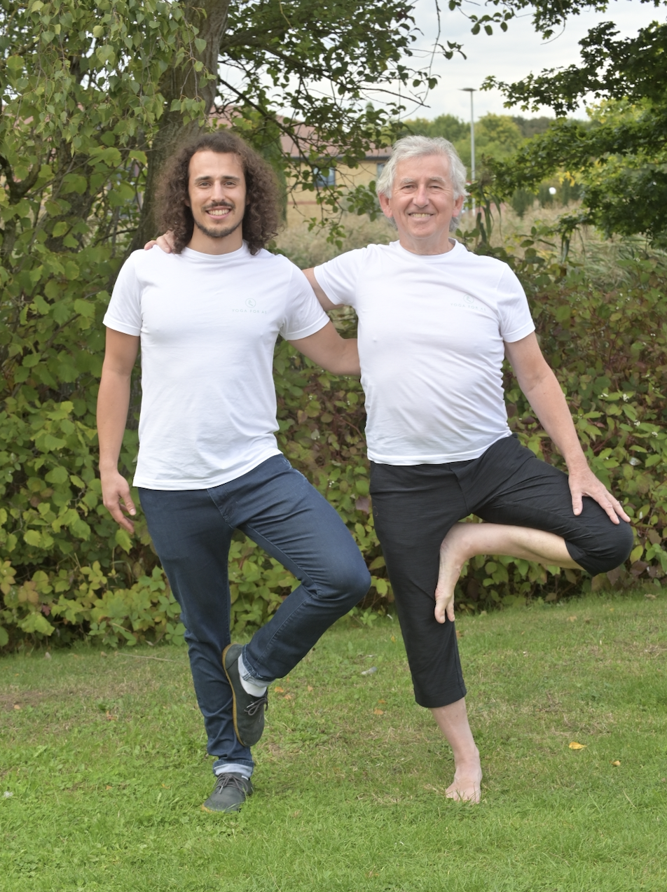 Two men, doing standing yoga.